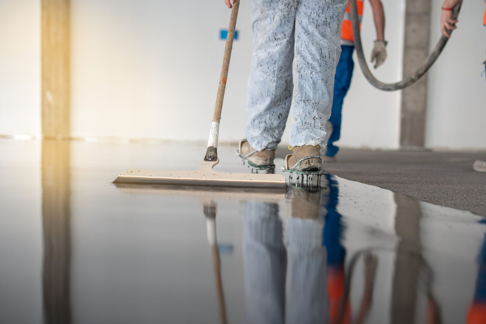 Installer spreading an epoxy base coat with spiked shoes