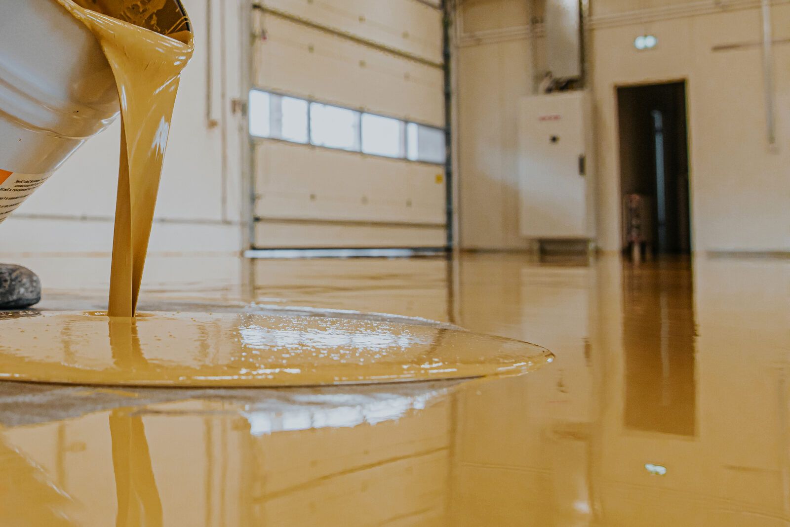 Resin being poured onto a prepared concrete floor